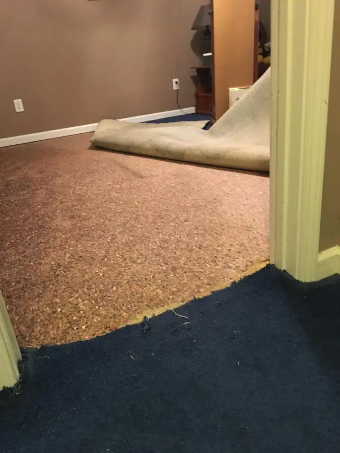 Carpet pad removal revealing water damage during Water Mitigation Services in Richmond Hill